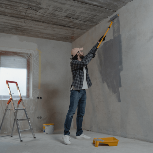 Fresh paint being applied to wall potentially covering up problems
