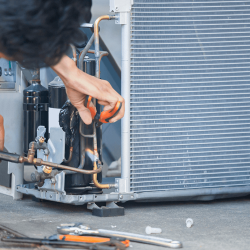 HVAC technician performing maintenance on air conditioning unit